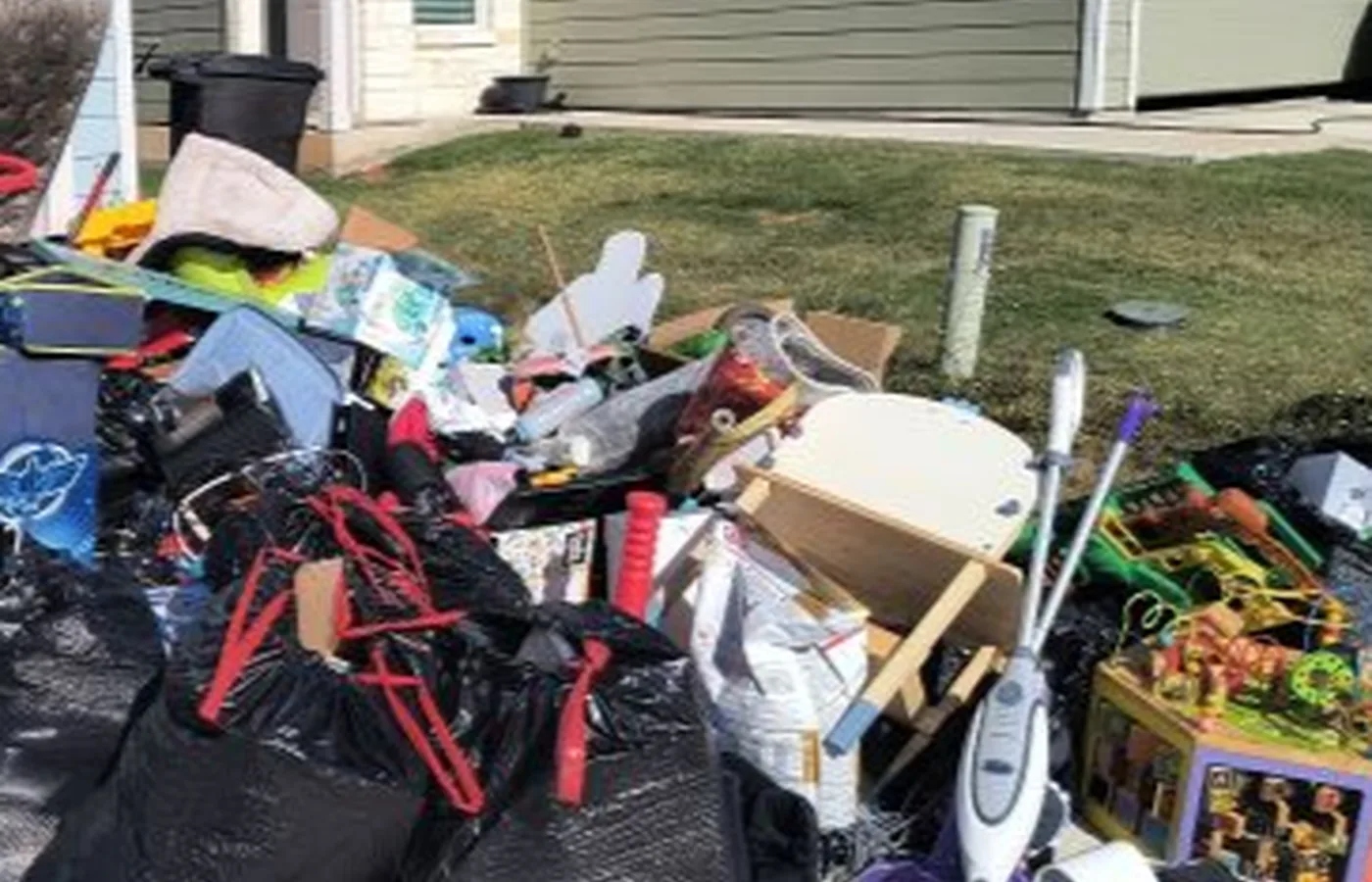 Mixed furniture and household belongings staged outdoors for a cleanout