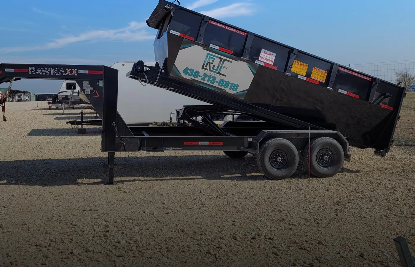 RJE 16-yard roll-off dumpster on its delivery trailer