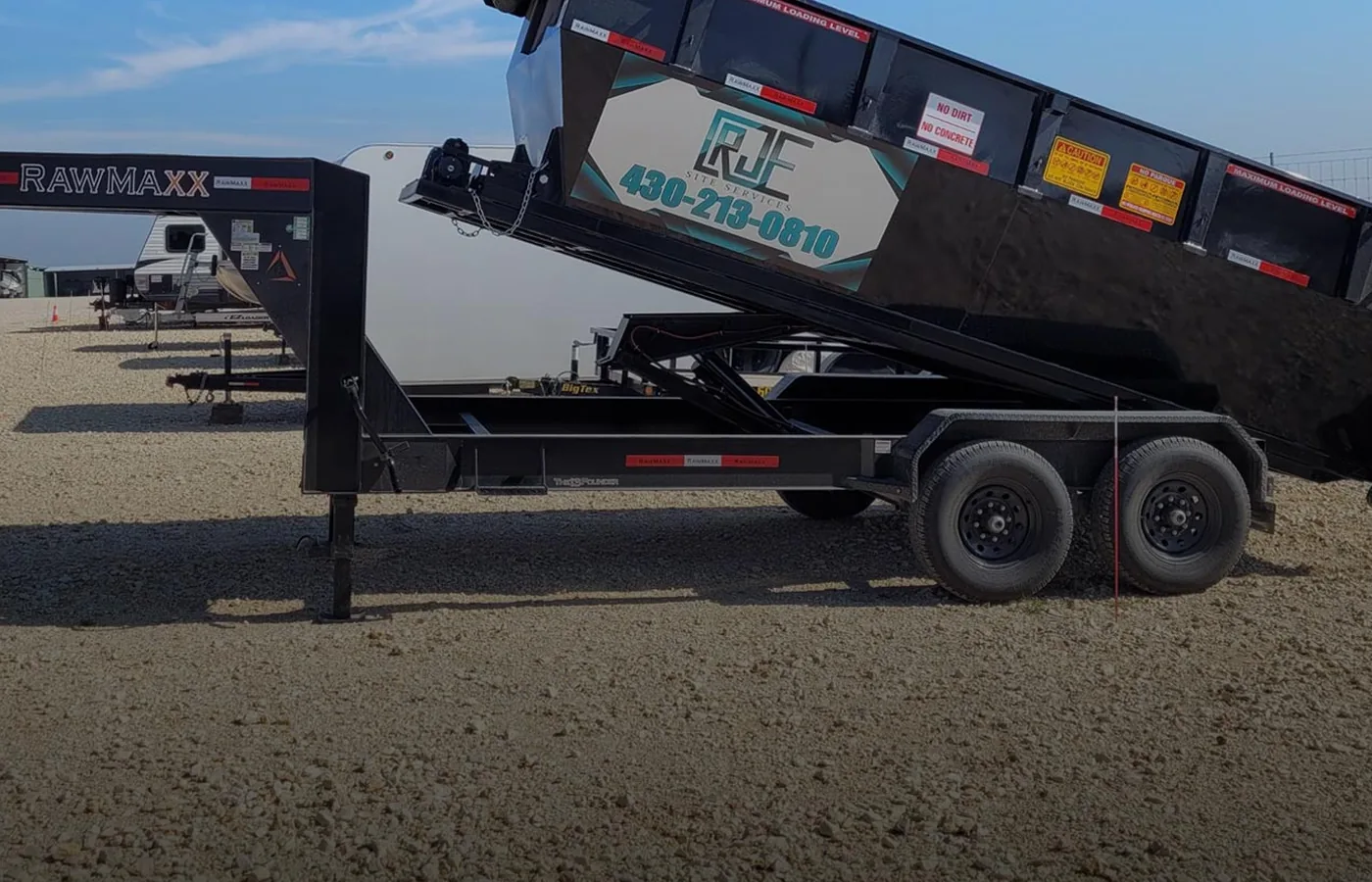 RJE roll-off dumpster shown on a delivery trailer before placement
