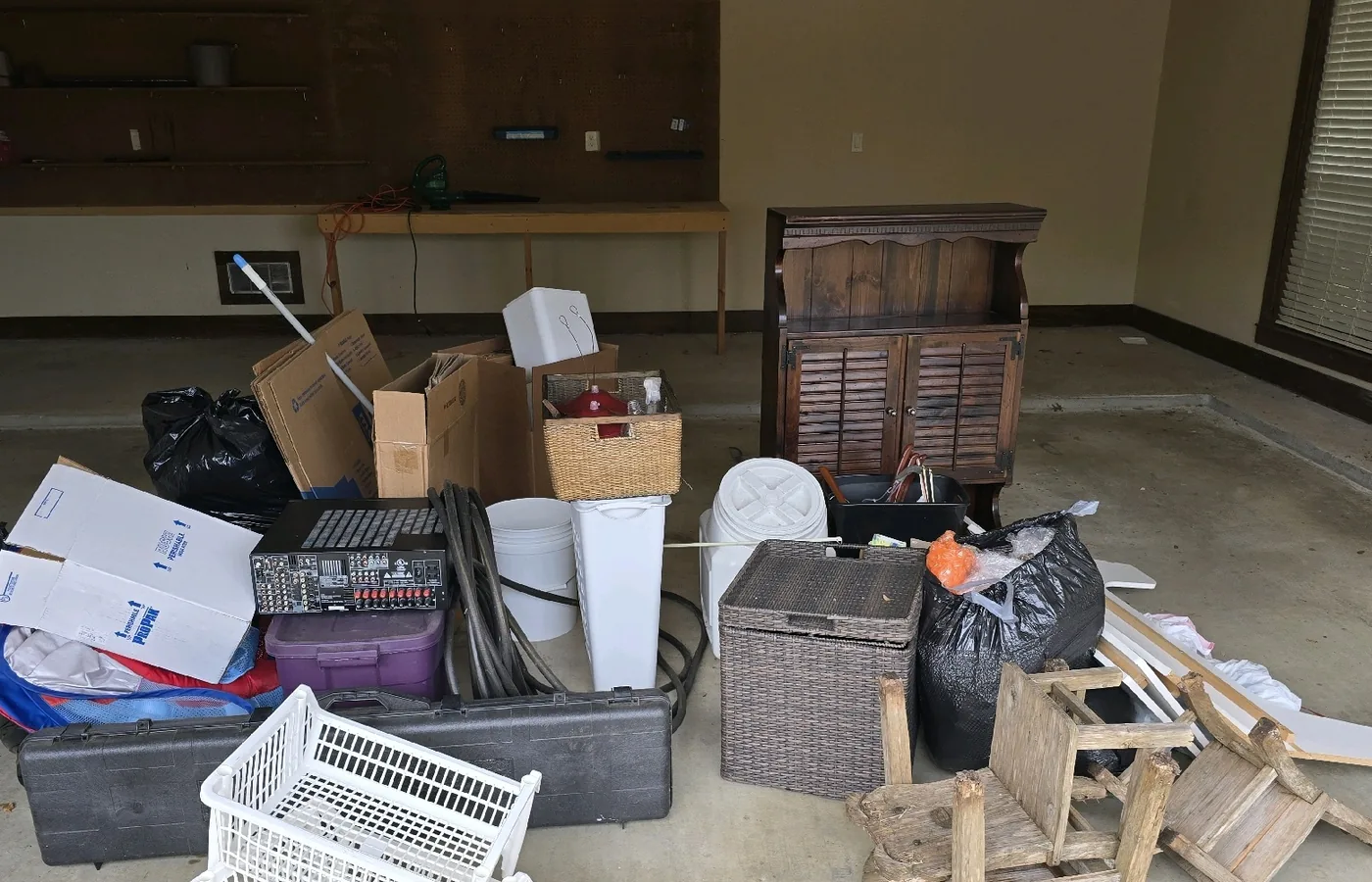 Furniture and household items grouped in a garage before removal